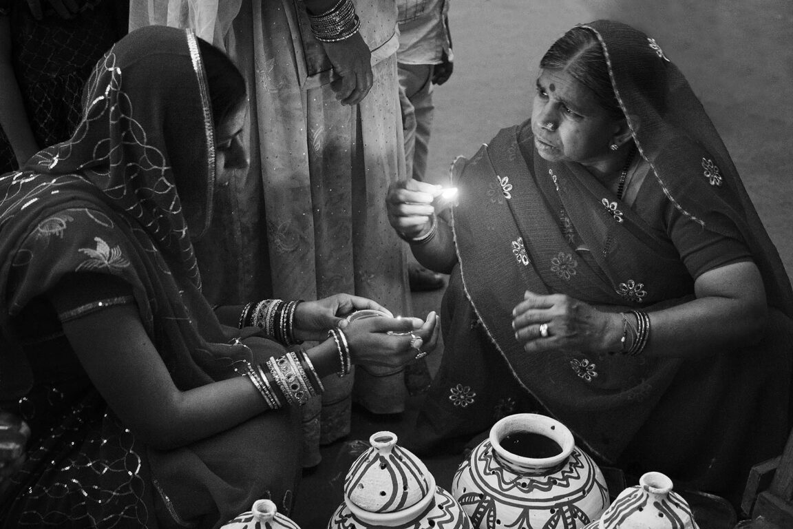 Rajasthani women place a candle in a clay pot as part of the GANGUR FESTIVAL in JOHDPUR - RAJASTHAN, INDIA