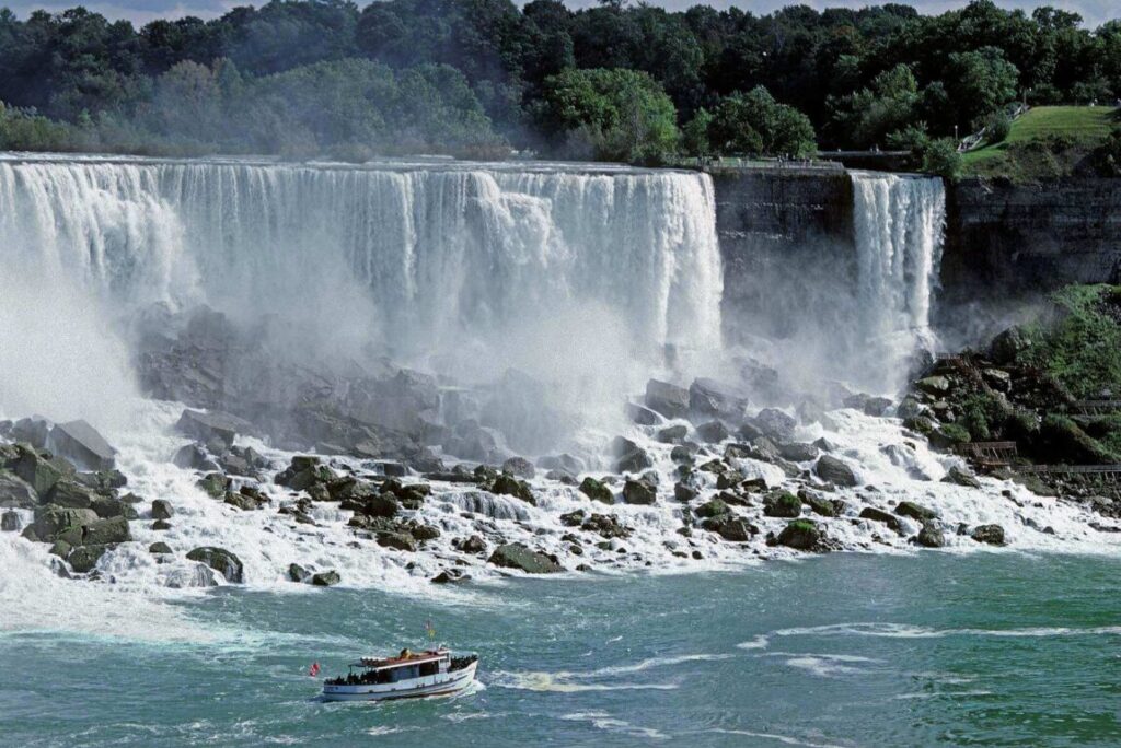 NIAGRA FALLS dwarfs a tour boat on the Canadian USA border